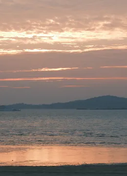 Shore: Evening over open water, hills on the far side.
